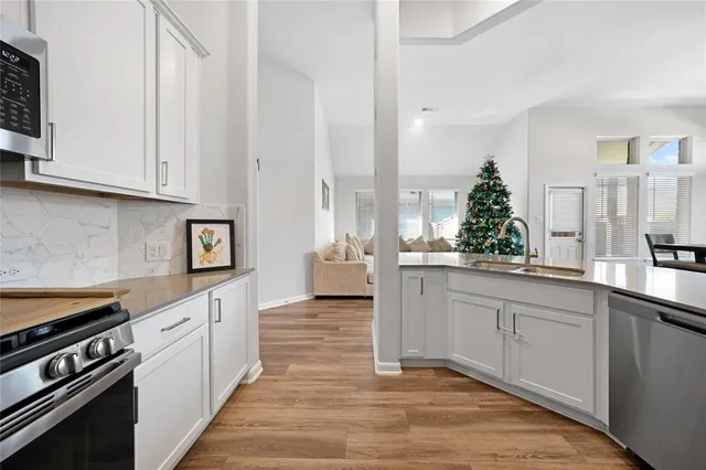 a kitchen with white cabinets and appliances