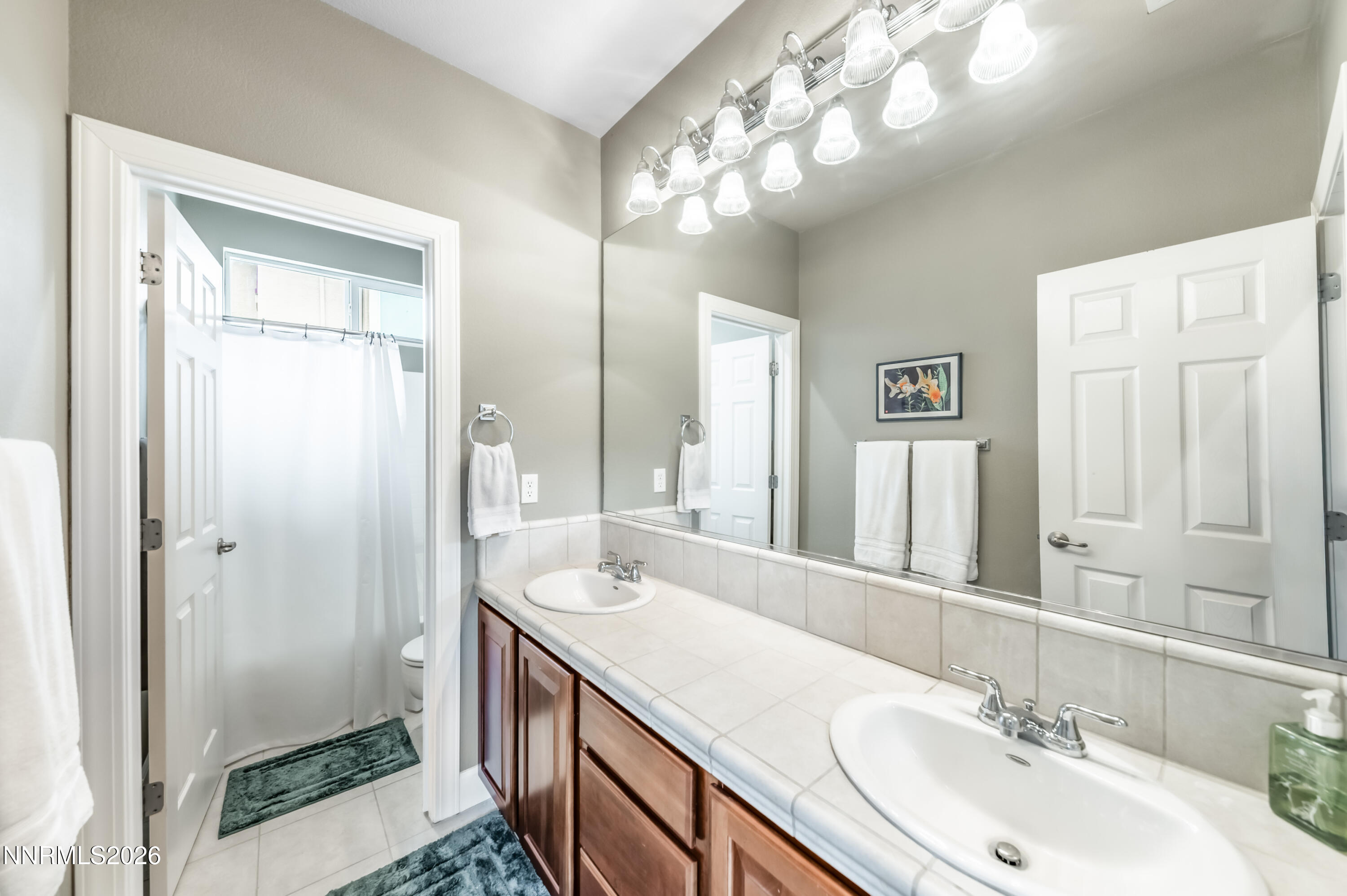 5865 Slate Drive Reno, NV 89523 - Photo 16 of 23 a bathroom with a double vanity sink and a mirror