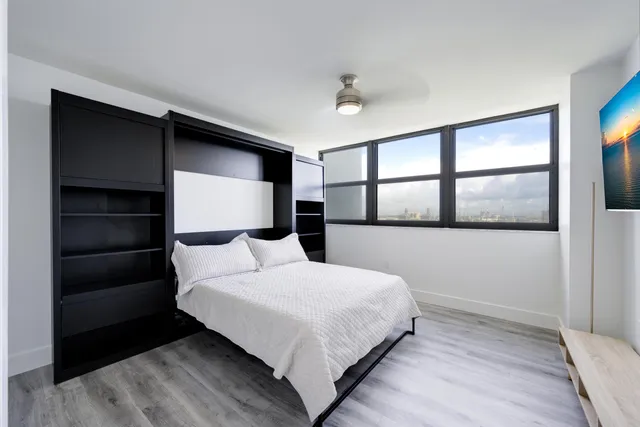 a bedroom with a large bed and a large window