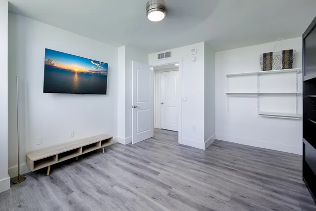 a view of a livingroom with wooden floor and a flat screen tv