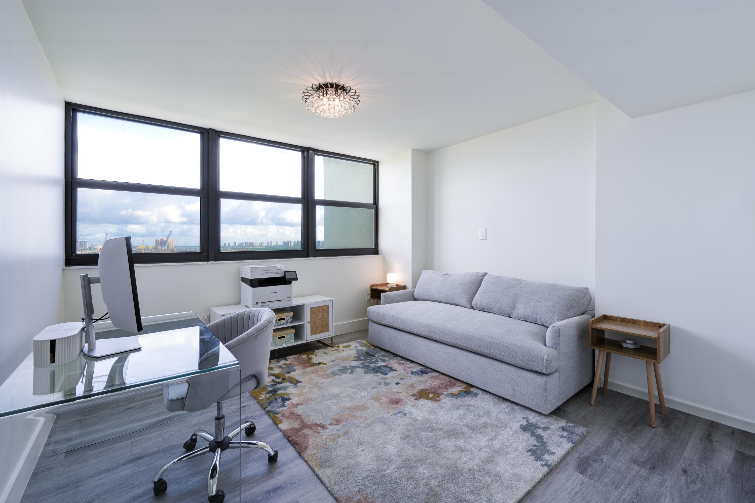 5600 North Flagler Drive, Unit 1207 West Palm Beach, FL 33407 - Photo 18 of 32 a living room with furniture a flat screen tv and a large window