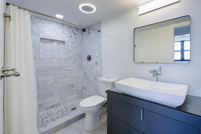 a bathroom with a sink a toilet and shower