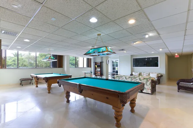 a living room with furniture pool table and a large window