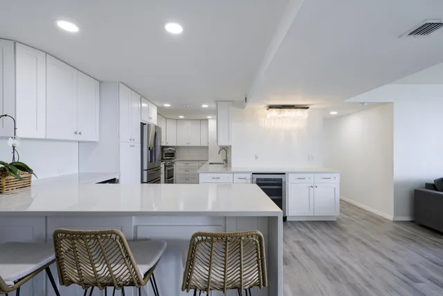a kitchen with stainless steel appliances kitchen island granite countertop a sink and wooden floor