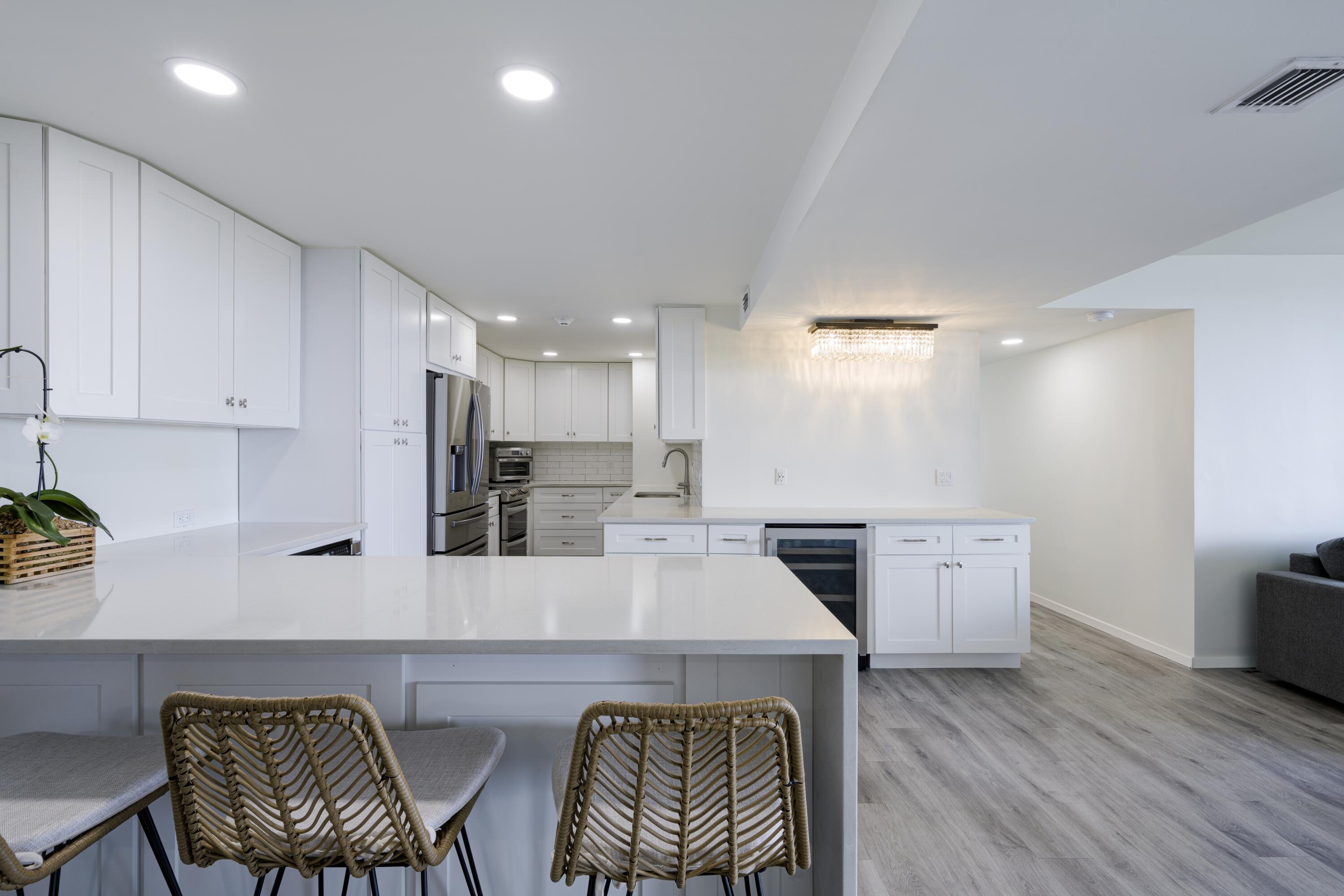 5600 North Flagler Drive, Unit 1207 West Palm Beach, FL 33407 - Photo 6 of 32 a kitchen with stainless steel appliances kitchen island granite countertop a sink and wooden floor