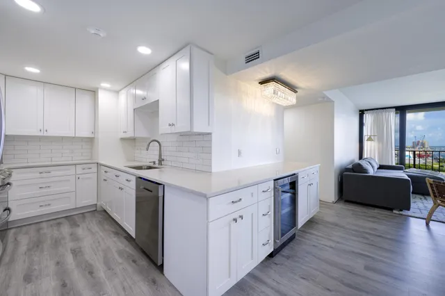 a large kitchen with cabinets wooden floor and stainless steel appliances