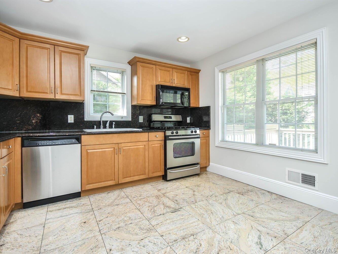 51 Inwood Road, Unit B Port Washington, NY 11050 - Photo 11 of 33 a kitchen with stainless steel appliances granite countertop a stove a sink and a microwave