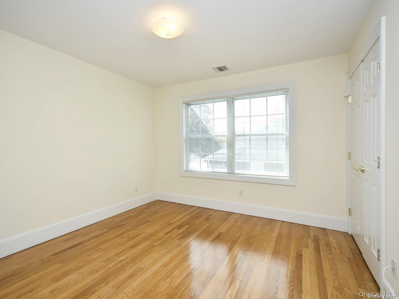 51 Inwood Road, Unit B Port Washington, NY 11050 - Photo 17 of 33 an empty room with wooden floor and windows