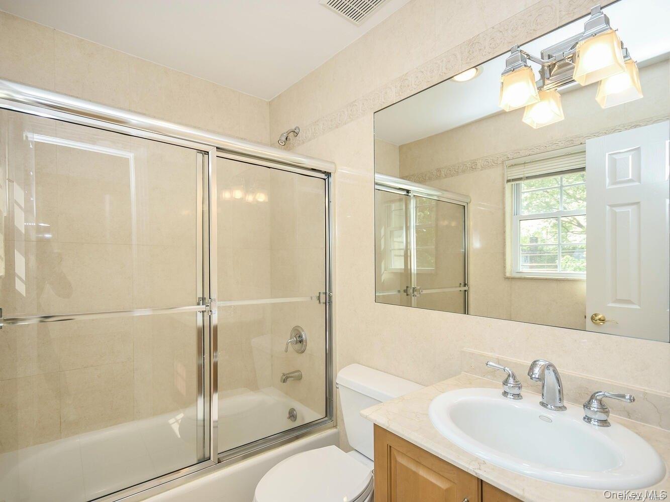 51 Inwood Road, Unit B Port Washington, NY 11050 - Photo 27 of 33 a bathroom with a shower sink vanity mirror and toilet