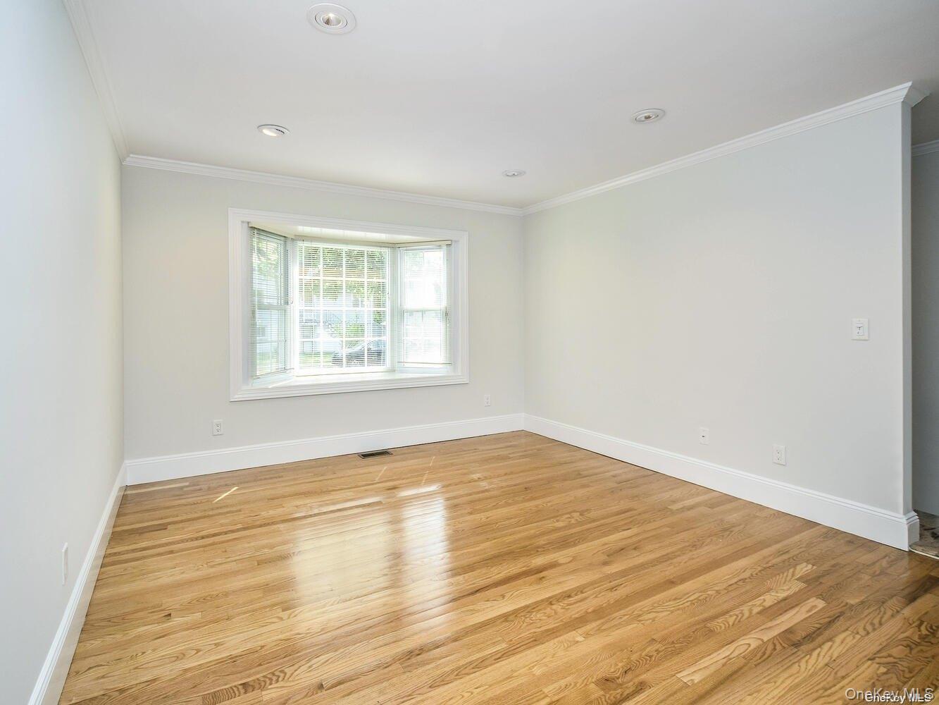 51 Inwood Road, Unit B Port Washington, NY 11050 - Photo 3 of 33 a view of an empty room with wooden floor and a window
