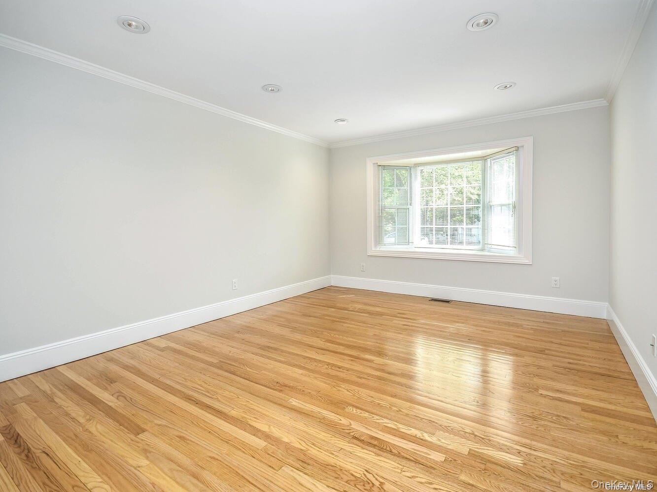 51 Inwood Road, Unit B Port Washington, NY 11050 - Photo 4 of 33 an empty room with wooden floor and windows