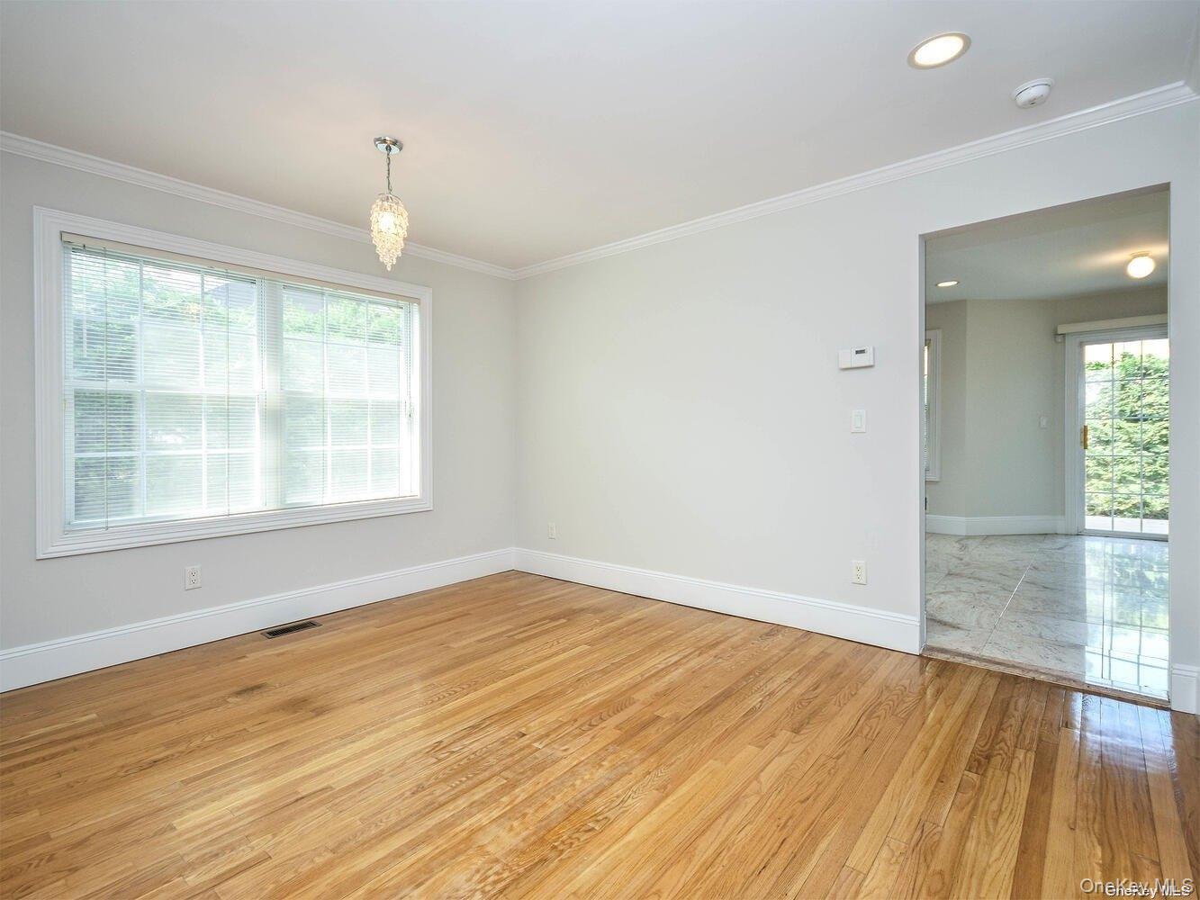 51 Inwood Road, Unit B Port Washington, NY 11050 - Photo 8 of 33 an empty room with wooden floor and windows