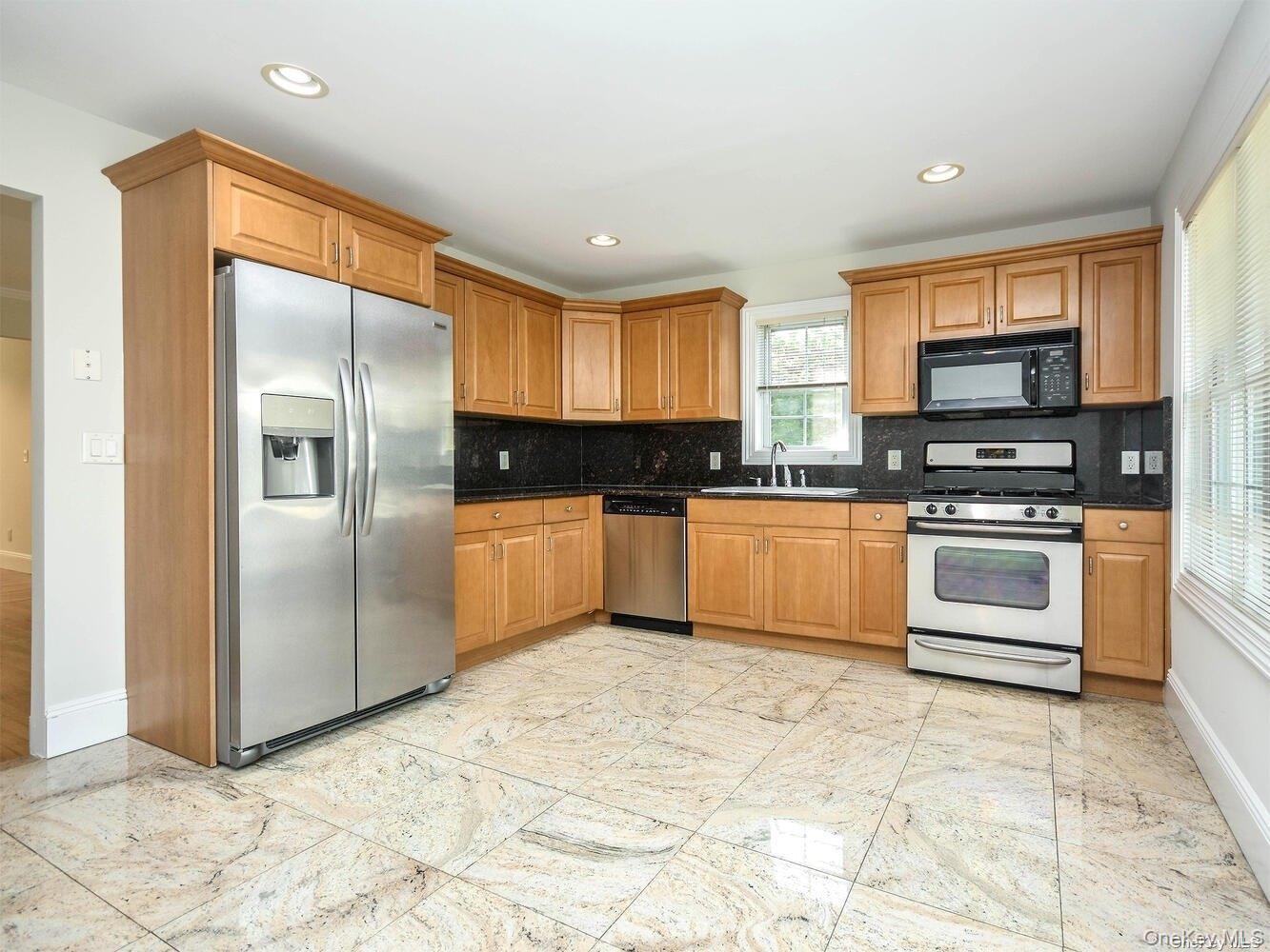 51 Inwood Road, Unit B Port Washington, NY 11050 - Photo 9 of 33 a kitchen with stainless steel appliances granite countertop a stove a sink and a refrigerator