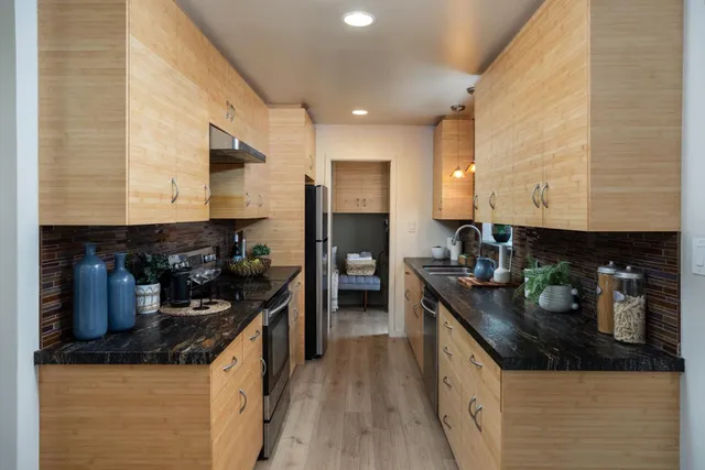 a bathroom with a granite countertop sink a toilet and shower