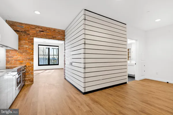 a view of a hallway with entryway and wooden floor