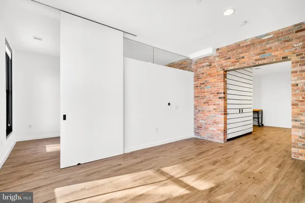 a view of a room with wooden floor and white walls