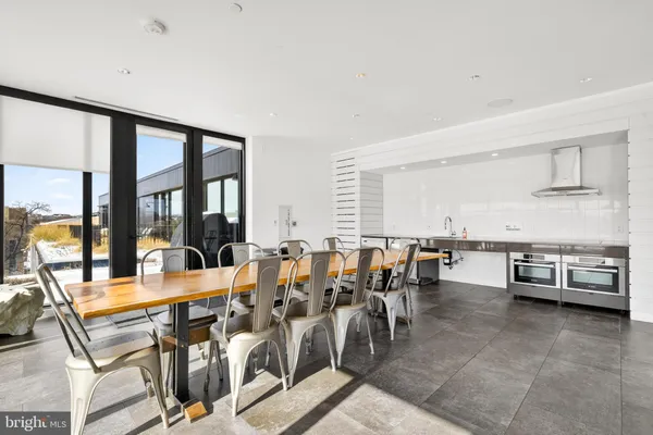 a very nice looking dining room with a large window and stainless steel appliances