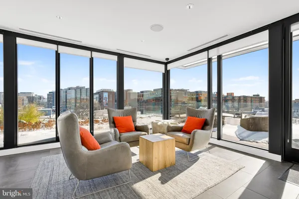 a living room with furniture and a floor to ceiling window
