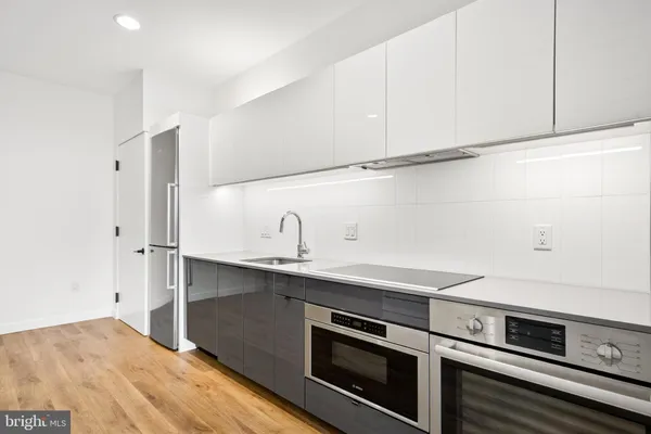 a kitchen with stainless steel appliances a sink stove and cabinets