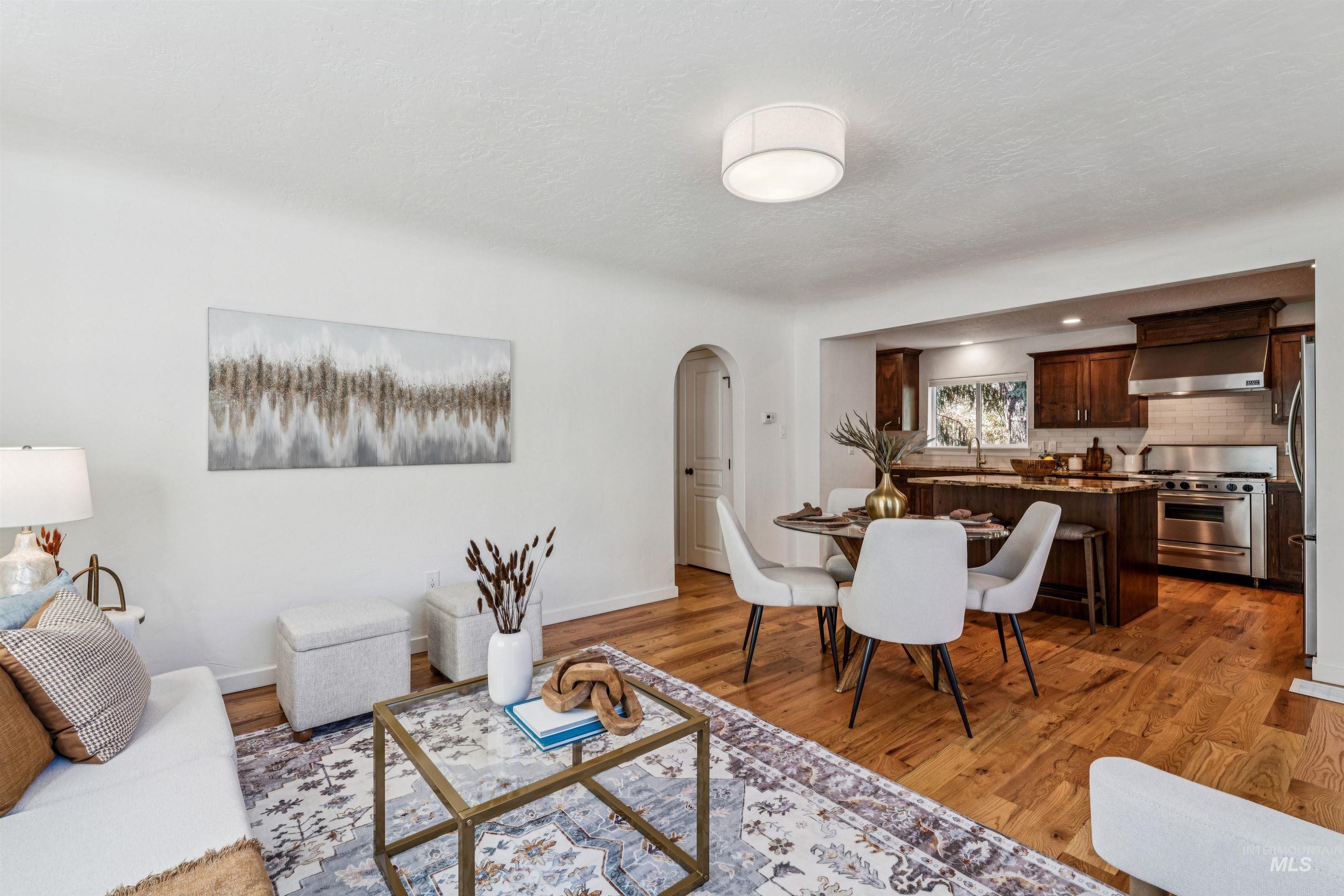 2419 West Hill Road Boise, ID 83702 - Photo 13 of 50 Great room featuring arched walkways, light wood finished floors, and a textured ceiling