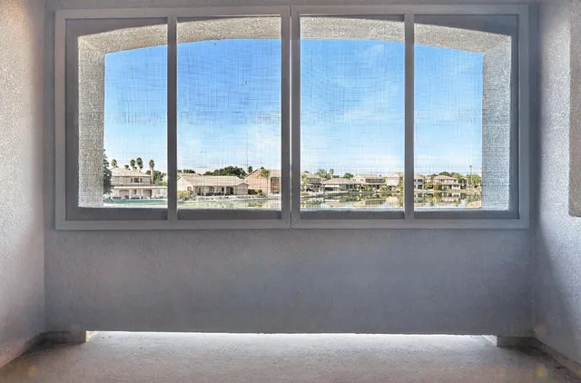 an empty room with a window and a ceiling fan