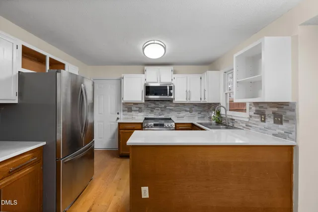 an empty room with windows and fireplace