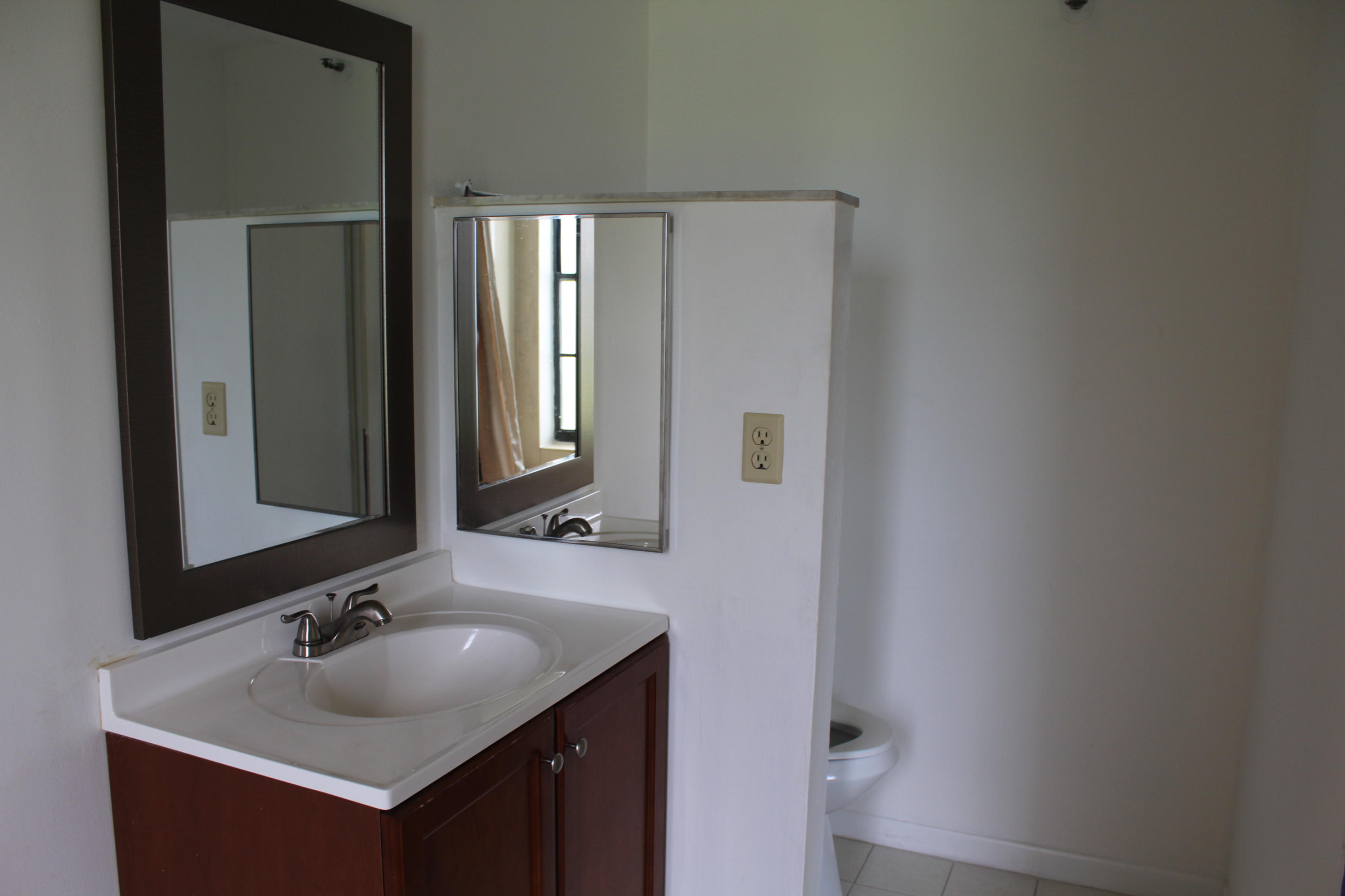 9235 Southwest 8th Street, Unit 503 Boca Raton, FL 33428 - Photo 16 of 27 a bathroom with a sink and a mirror