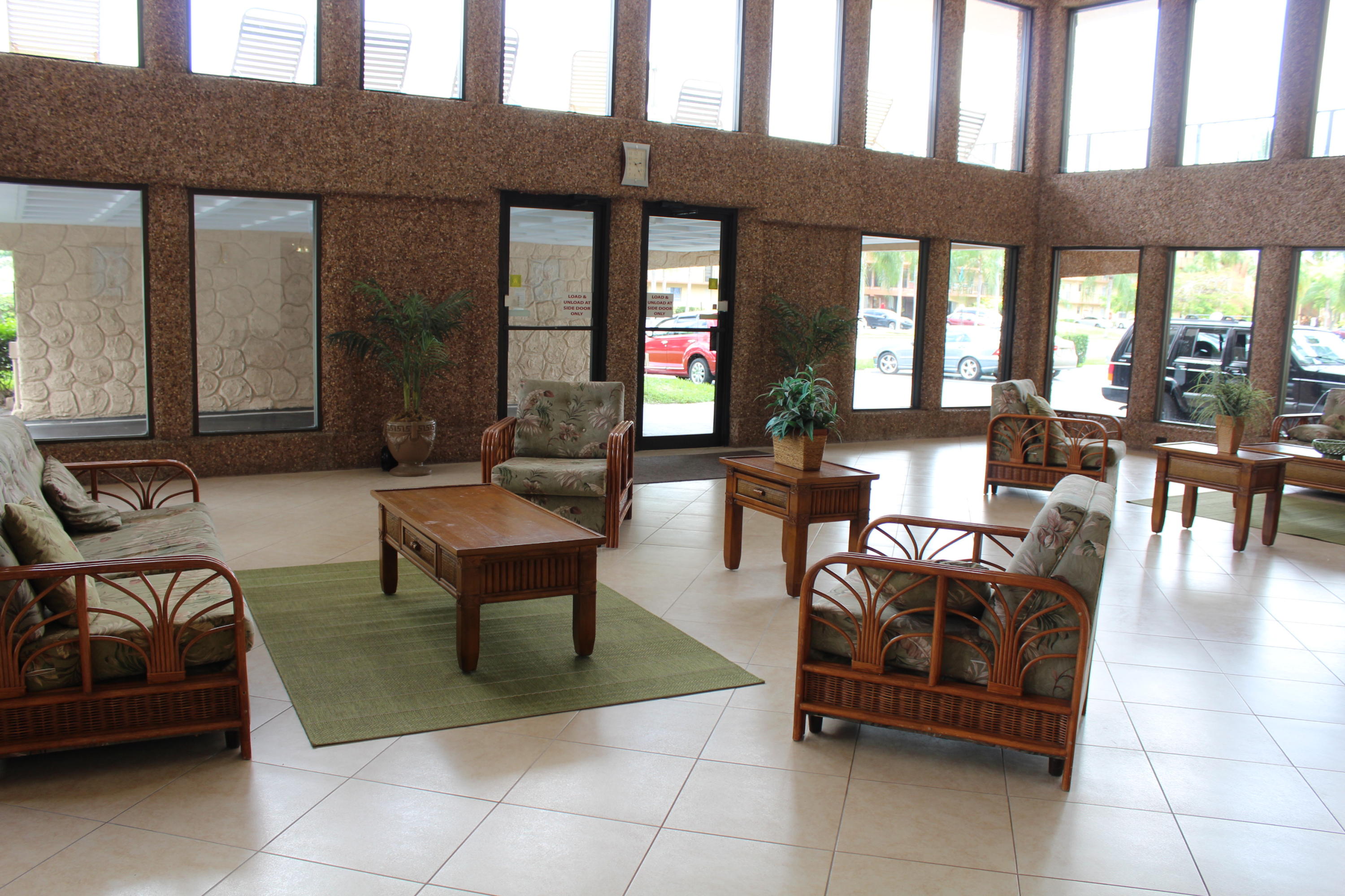 9235 Southwest 8th Street, Unit 503 Boca Raton, FL 33428 - Photo 2 of 27 a living room with furniture and a floor to ceiling window