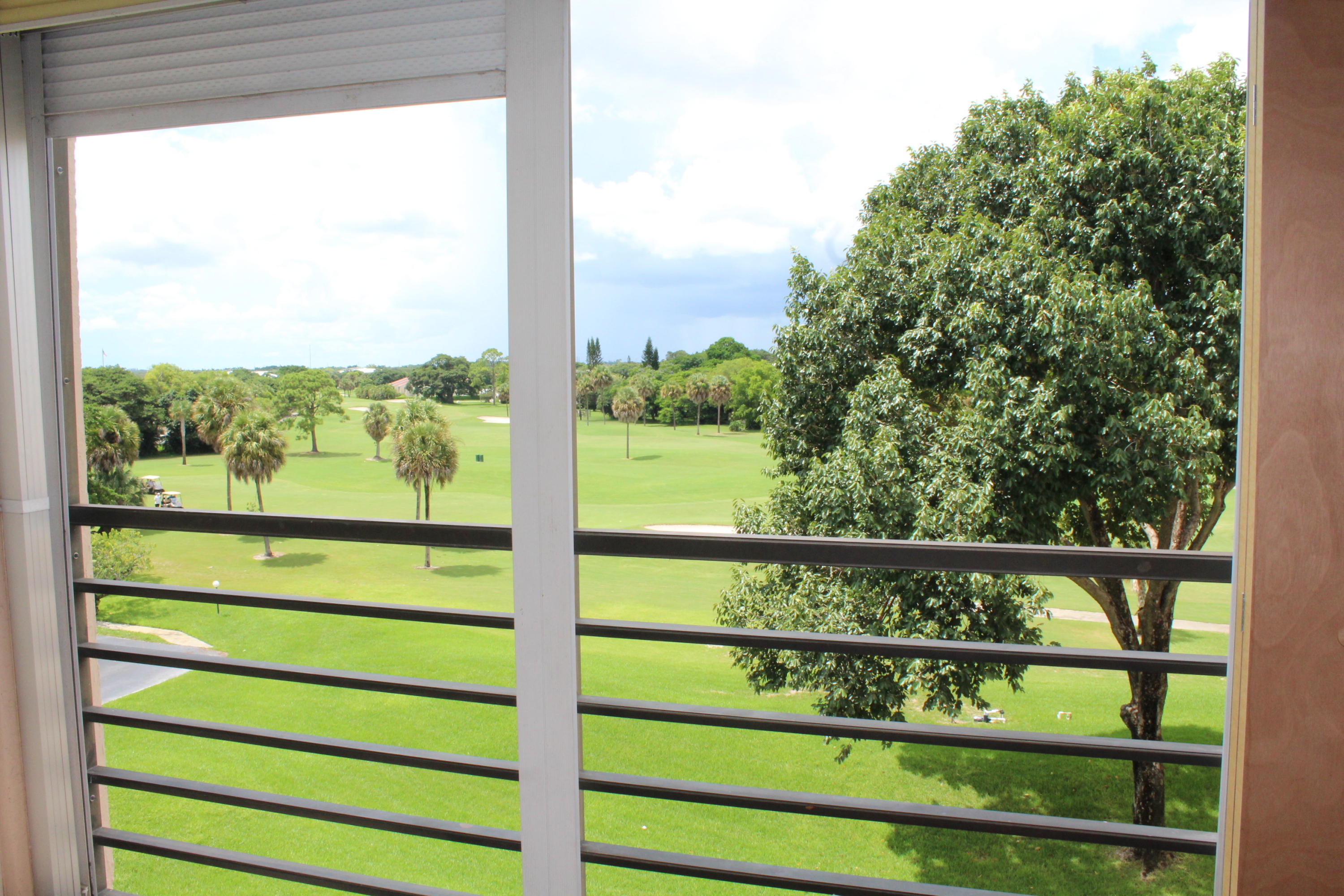 9235 Southwest 8th Street, Unit 503 Boca Raton, FL 33428 - Photo 25 of 27 a view of a green field with wooden fence