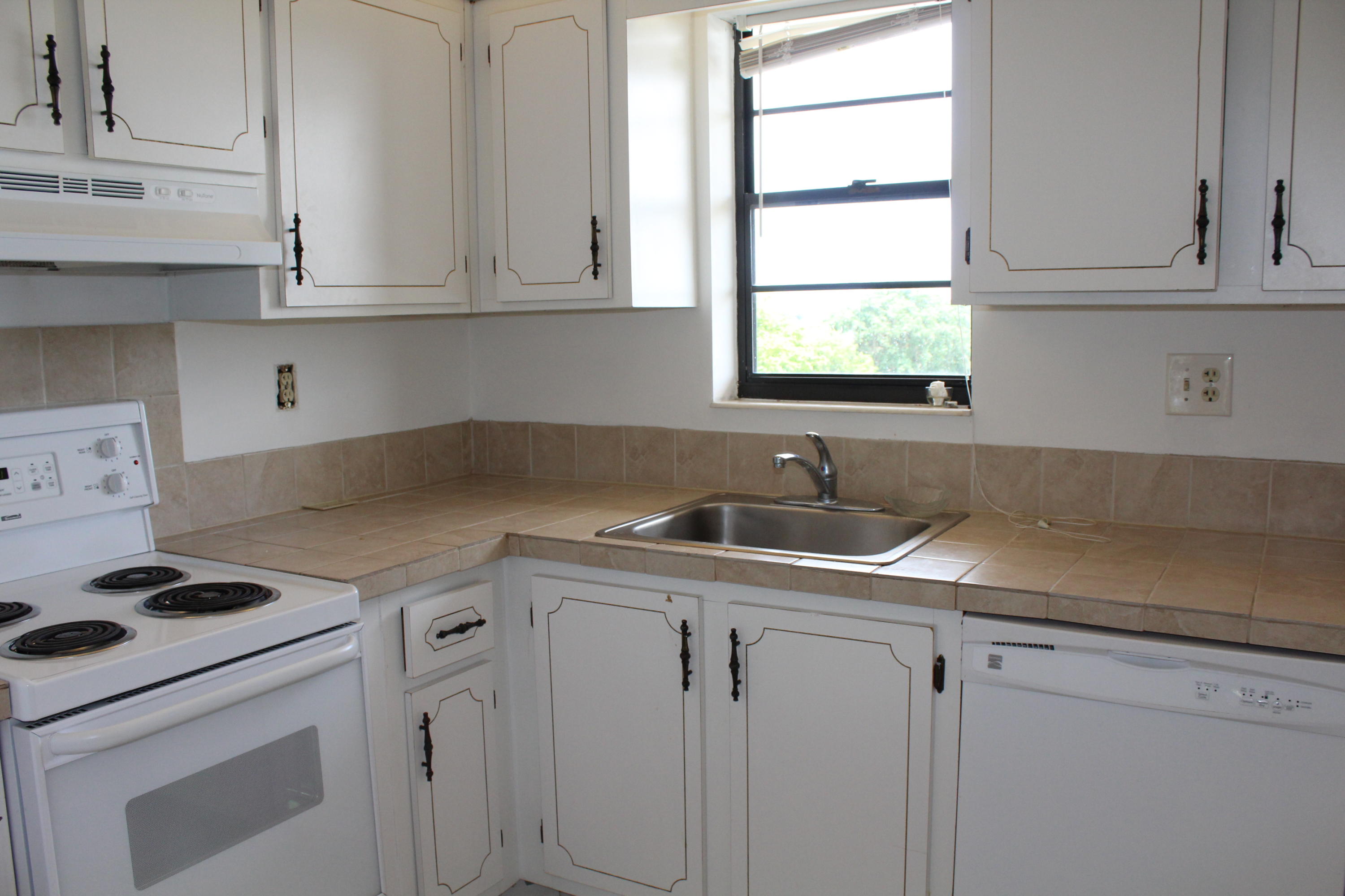 9235 Southwest 8th Street, Unit 503 Boca Raton, FL 33428 - Photo 9 of 27 a kitchen with appliances cabinets and a window