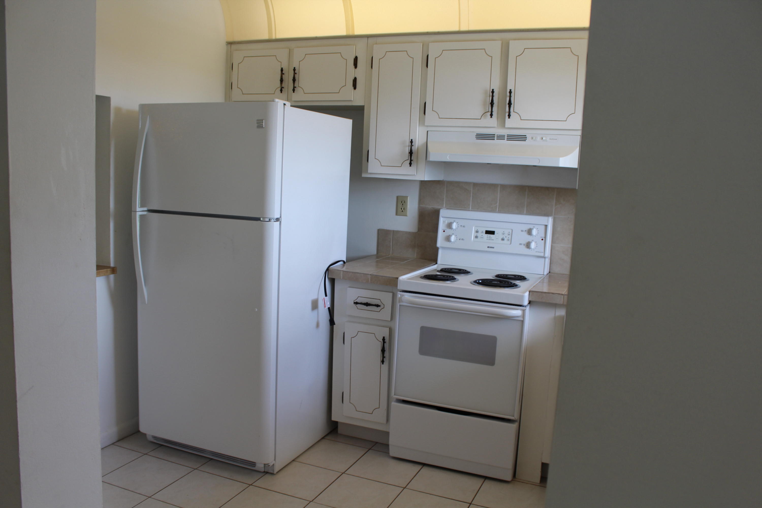 9235 Southwest 8th Street, Unit 503 Boca Raton, FL 33428 - Photo 10 of 27 a kitchen with stainless steel appliances white cabinets and a refrigerator