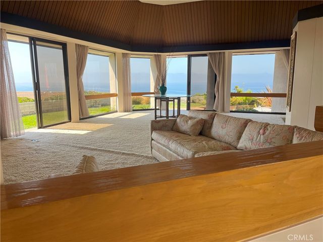 a view of an empty room with a fireplace and large windows