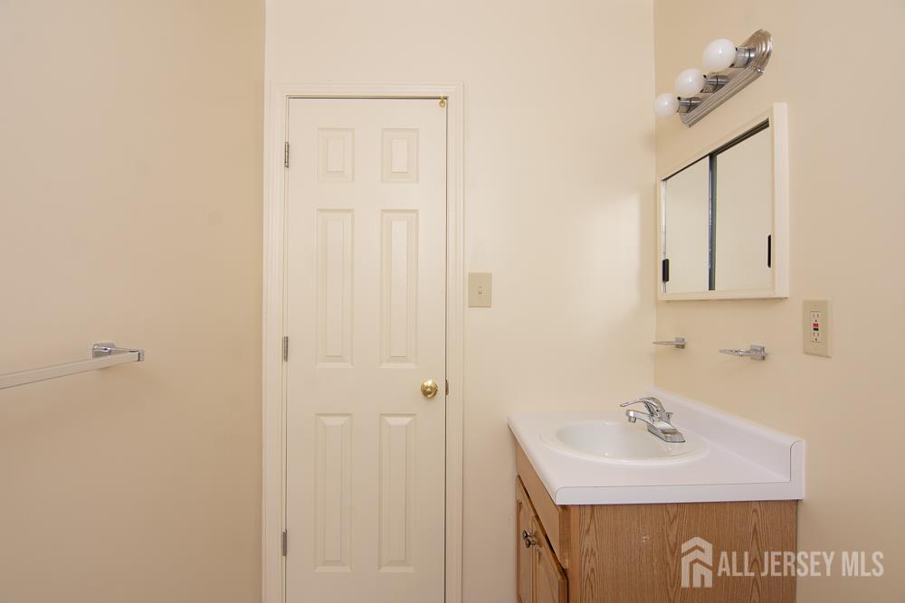 9 Koster Boulevard, Unit A Edison, NJ 08837 - Photo 13 of 15 a bathroom with a sink and a mirror