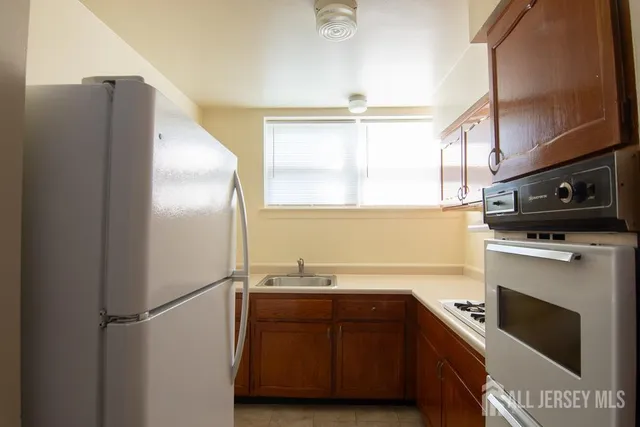 a kitchen with stainless steel appliances a refrigerator sink and microwave