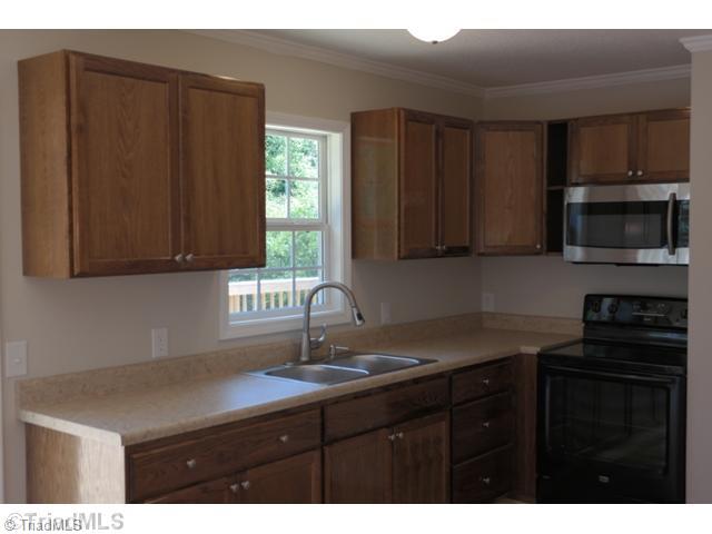 1708 Foust Road Greensboro, NC 27405 - Photo 2 of 9 Kitchen. Newly remodeled kitchen with new oak cabinets with brushed nickel hardware, new slide in oven/range and black and stainless microwave, new counter tops and upgraded brushed nickel faucet with pull out sprayer and double bowl ss sink