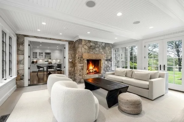 a living room with furniture fireplace and a large window