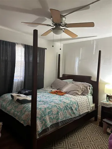 a bedroom with a bed a dresser and potted plants