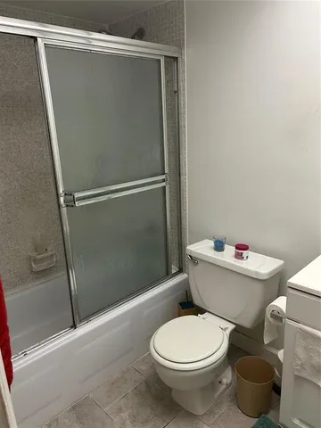 a white toilet sitting next to a bath tub