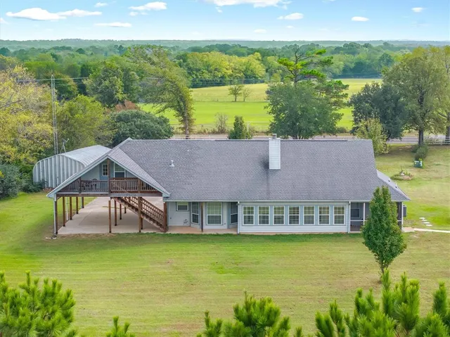 a view of a house with backyard and sitting area