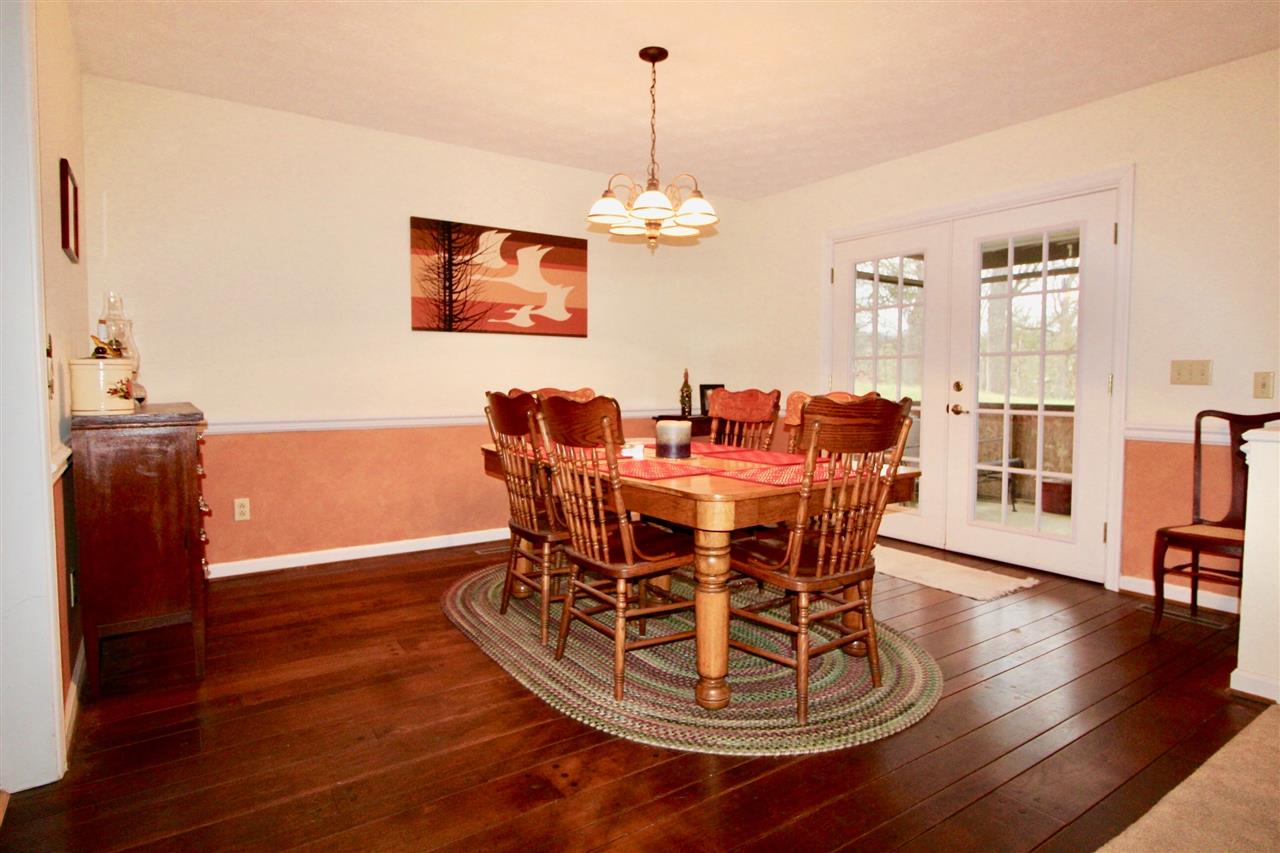 31 West Roman Ridge Road Mount Sidney, VA 24467 - Photo 8 of 23 a dining room with wooden floor a chandelier a wooden table and chairs