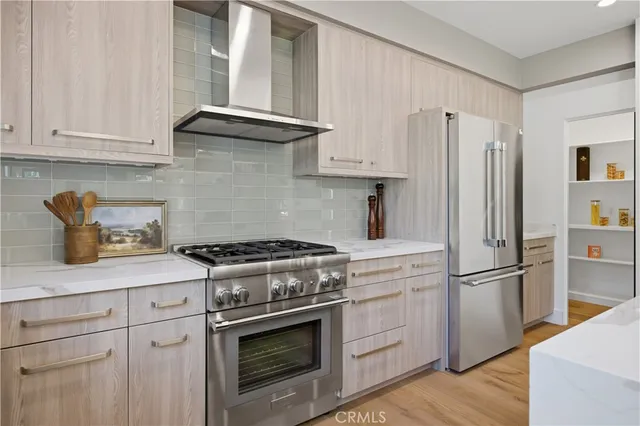 a kitchen with stainless steel appliances white cabinets and a stove top oven
