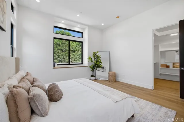 a bedroom with a bed and a large window