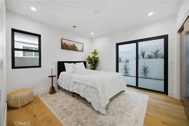 a bedroom with a large bed and a potted plant
