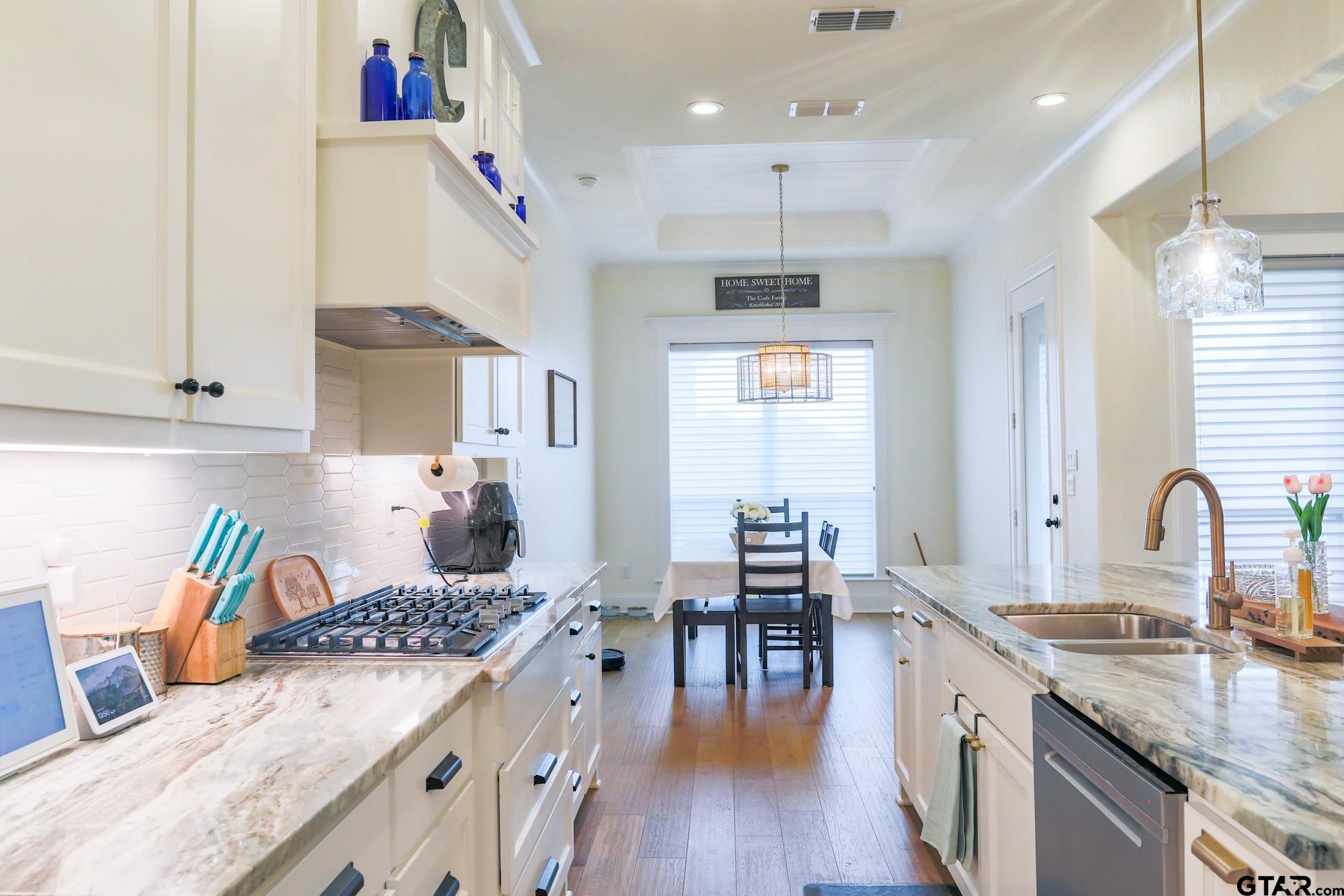 9065 Shallow Cove Tyler, TX 75703 - Photo 15 of 40 a kitchen with granite countertop a stove a sink a refrigerator and wooden floor