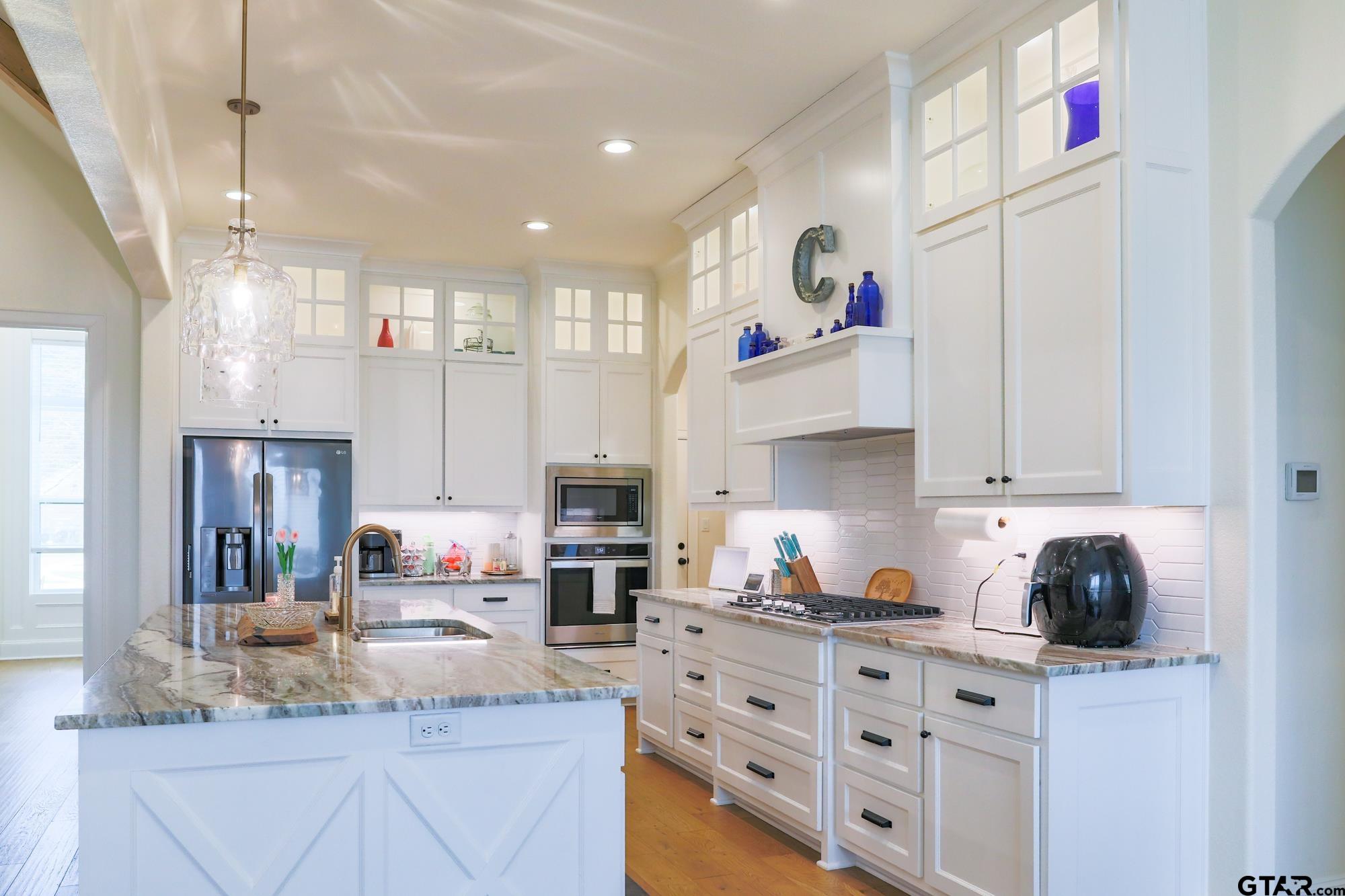 9065 Shallow Cove Tyler, TX 75703 - Photo 17 of 40 a kitchen with granite countertop a sink stove and cabinets