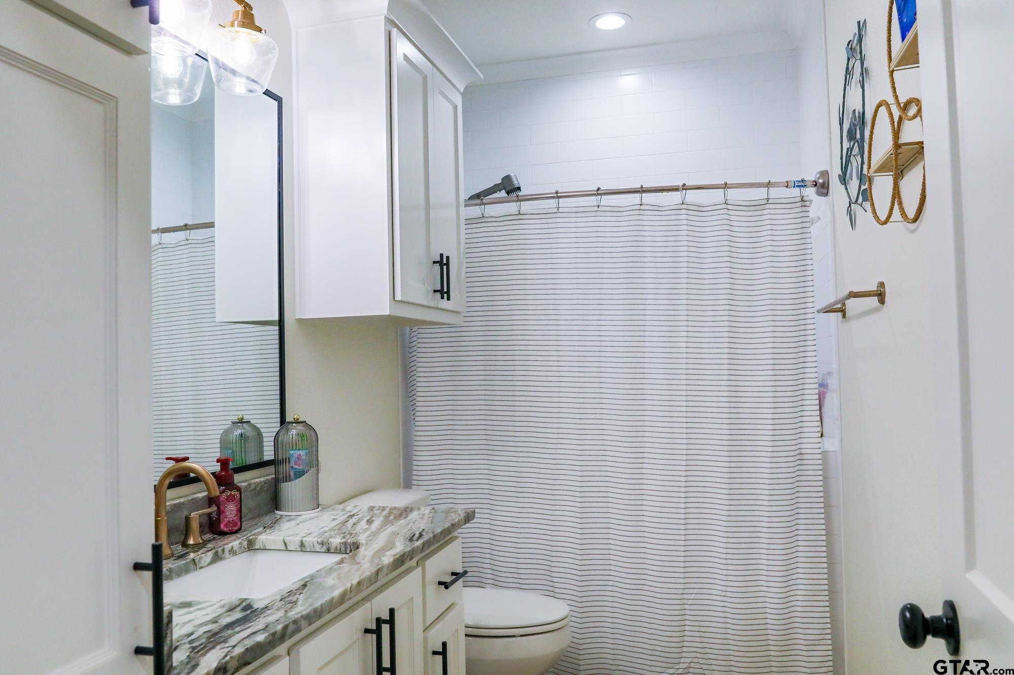 9065 Shallow Cove Tyler, TX 75703 - Photo 34 of 40 a bathroom with a sink toilet and shower