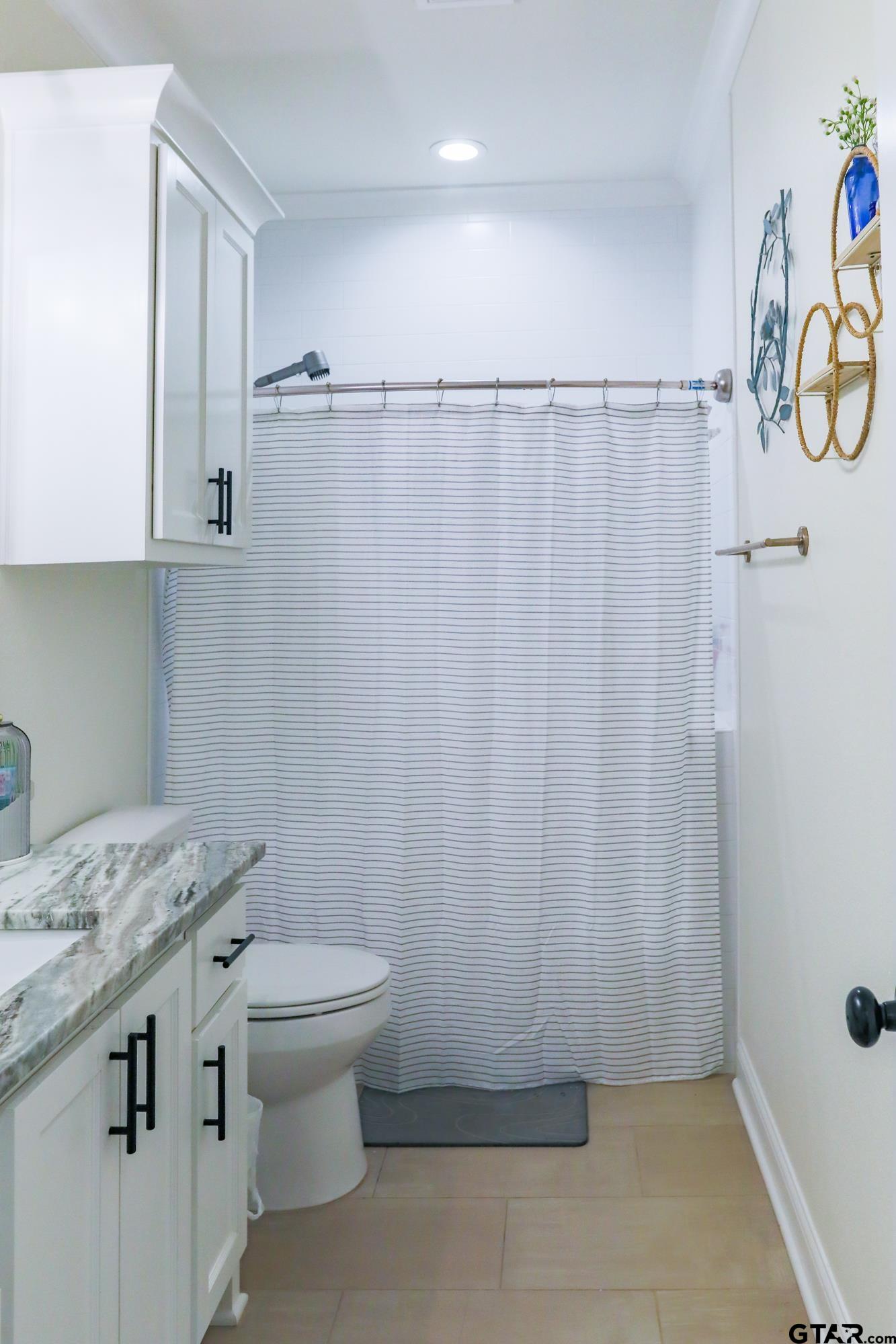 9065 Shallow Cove Tyler, TX 75703 - Photo 35 of 40 a bathroom with a granite countertop sink toilet and shower