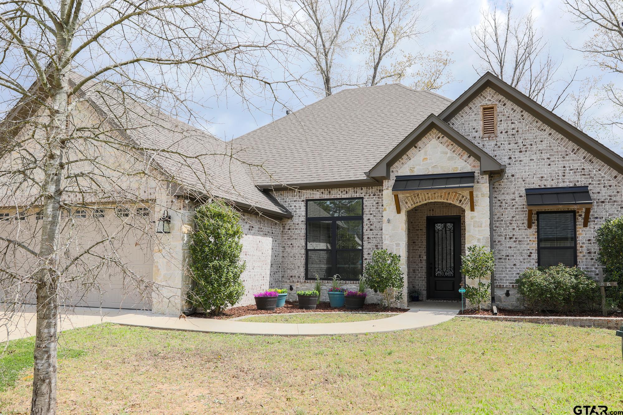9065 Shallow Cove Tyler, TX 75703 - Photo 4 of 40 a front view of a house with a yard and garage