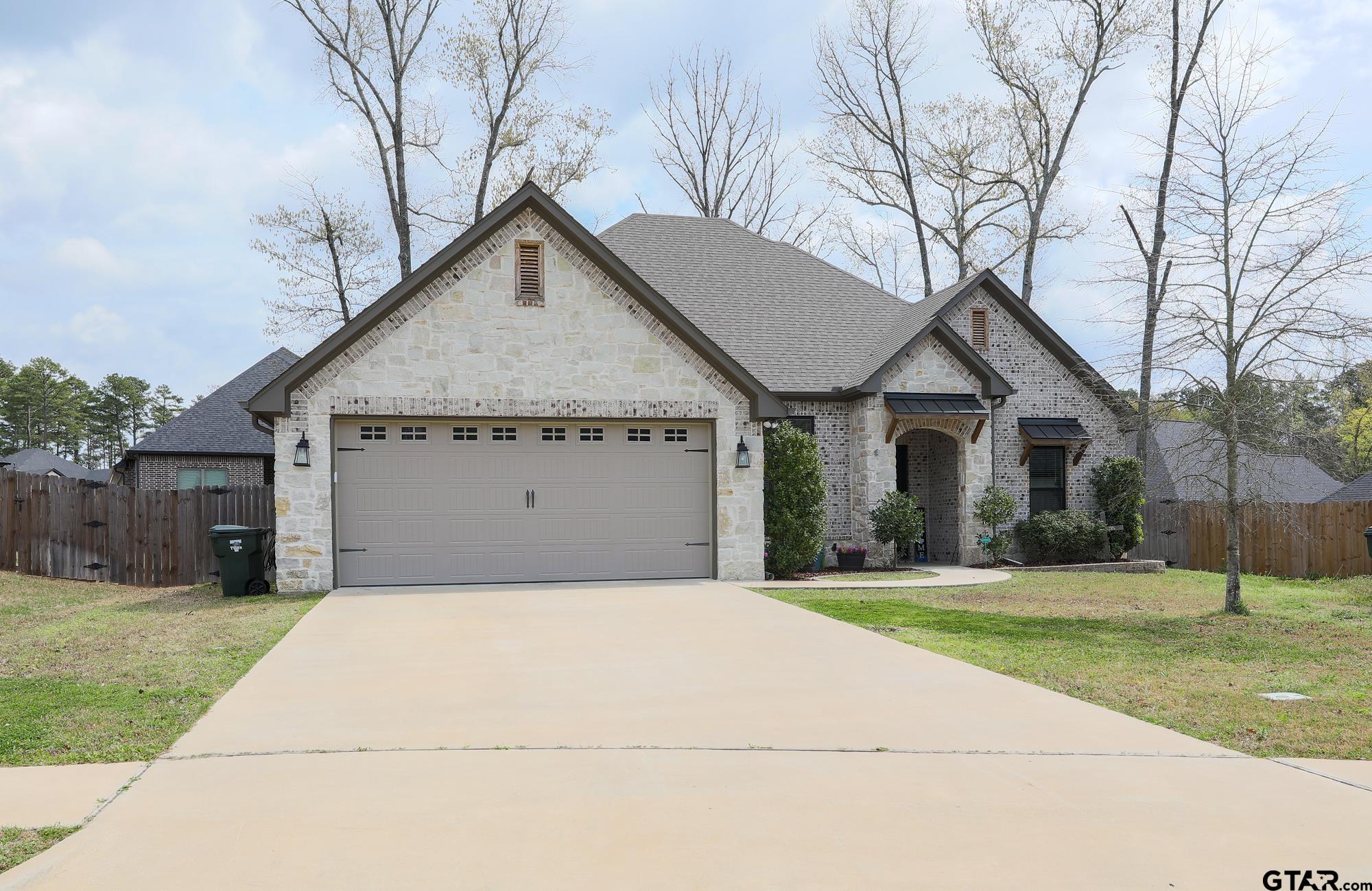9065 Shallow Cove Tyler, TX 75703 - Photo 7 of 40 a front view of a house with a yard and garage