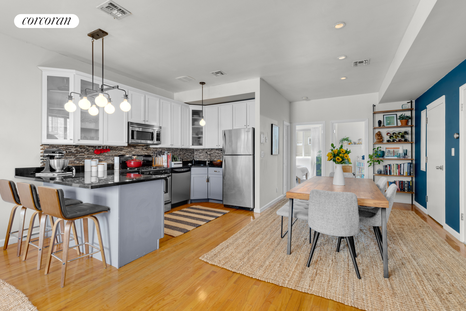 a kitchen with stainless steel appliances granite countertop a table chairs and a refrigerator